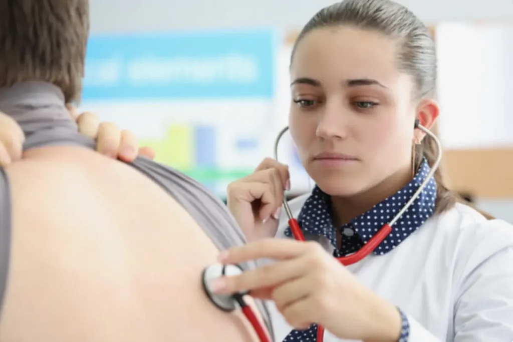 Pulmonolog osłuchująca pacjenta. Źródło: Canva.com