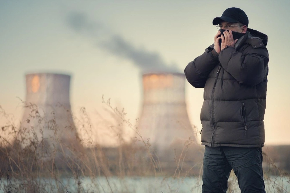 Smog mężczyzna na tle kominów